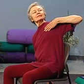 woman in sitting in chair stretches one arm behind her